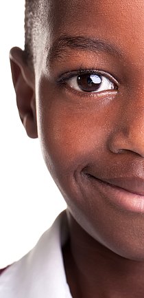 Foto em close do rosto de um menino sorrindo