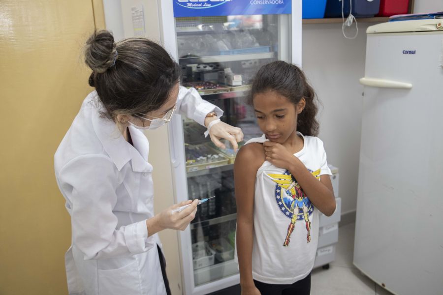 Enfermeira vacinando no braço criança